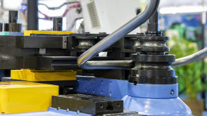 Industrial welder performing MIG welding on custom steel frames in a Michigan fabrication facility