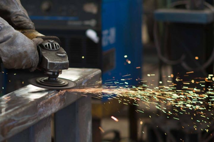 Michigan's EV transition in action: welding spark from precision metal fabrication machine creating an electric vehicle component.